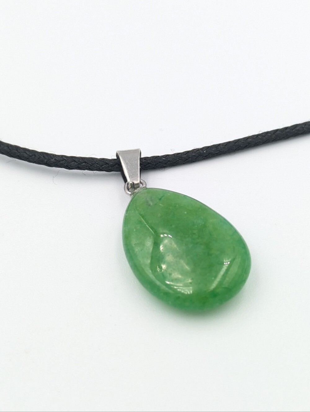 Polished green stone pendant on black cord necklace